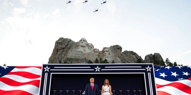 President Donald Trump, accompanied by first lady Melania Trump, stand during a flyover at Mount Rushmore National Memorial, Friday, July 3, 2020, near Keystone, S.D. 