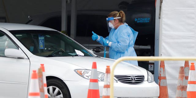 A health-care worker at a drive-through coronavirus testing site Sunday in Miami Gardens, Fla. 