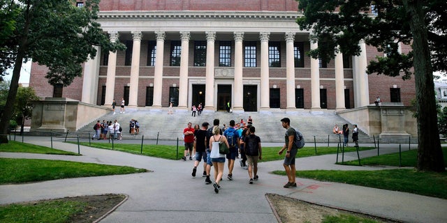 In this Aug. 13, 2019 file photo, students walk near the Widener Library in Harvard Yard at Harvard University in Cambridge, Mass. The Ivy League school announced Monday that as the coronavirus pandemic continues its freshman class will be invited to live on campus this fall, while most other undergraduates will be required to learn remotely from home. (AP Photo/Charles Krupa, File)