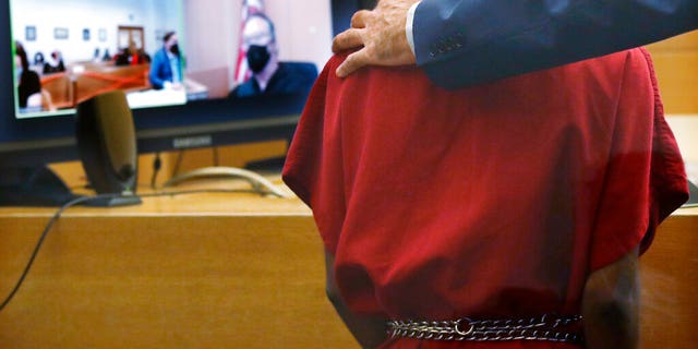 Attorney John Henry Browne puts his arm over the shoulders of Dawit Kelete as Kelete makes a court appearance before Judge Mark Chow, on video, Monday, July 6, 2020, in Seattle. Kelete is accused of driving a car onto a closed Seattle freeway and hitting two protesters, killing one, over the weekend. Seattle has been the site of prolonged unrest over the death of George Floyd, a Black man who was in police custody in Minneapolis.