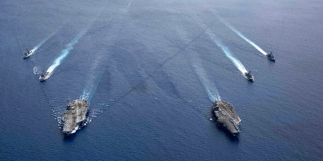 In this photo provided by U.S. Navy, the USS Ronald Reagan (CVN 76) and USS Nimitz (CVN 68) Carrier Strike Groups steam in formation, in the South China Sea, Monday, July 6, 2020. China on Monday, July 6, accused the U.S. of flexing its military muscles in the South China Sea by conducting joint exercises with two U.S. aircraft carrier groups in the strategic waterway.(Mass Communication Specialist 3rd Class Jason Tarleton/U.S. Navy via AP)