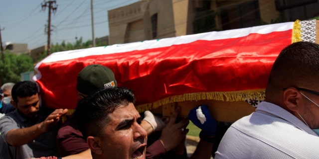 Mourners carry the flag-draped coffin of Hisham al-Hashimi during his funeral, in the Zeyouneh area of Baghdad, Iraq, Tuesday, July, 7, 2020. Al-Hashimi, an Iraqi analyst who was a leading expert on the Islamic State and other armed groups, was shot dead in Baghdad on Monday. (AP Photo/Khalid Mohammed)