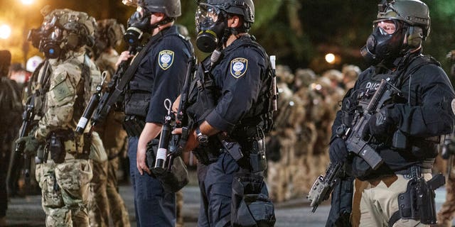 Agents from different components of the Department of Homeland Security are deployed to protect a federal courthouse in Portland, Ore., on Sunday, July 5, 2020. (Doug Brown via AP)