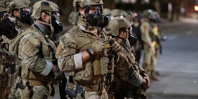 In this photo provided by Doug Brown, agents from different components of the Department of Homeland Security are deployed to protect a federal courthouse in Portland, Ore., Sunday, July 5, 2020. Protesters who have clashed with authorities in Portland are facing off not just against city police but a contingent of federal agents who reflect a new priority for the Department of Homeland Security: preventing what President Donald Trump calls 