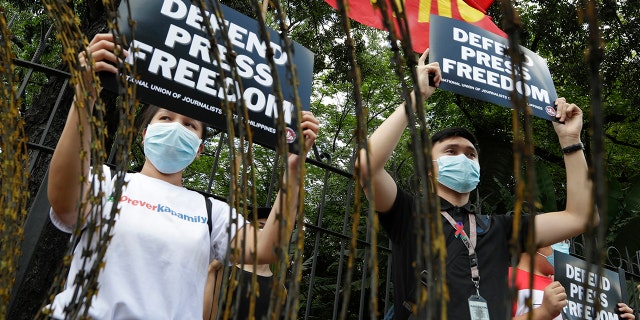 Supporters of the country's largest TV network, ABS-CBN, holds slogans during a rally outside the House of Representatives in Manila, Philippines, Thursday, July 9, 2020. (Associated Press)