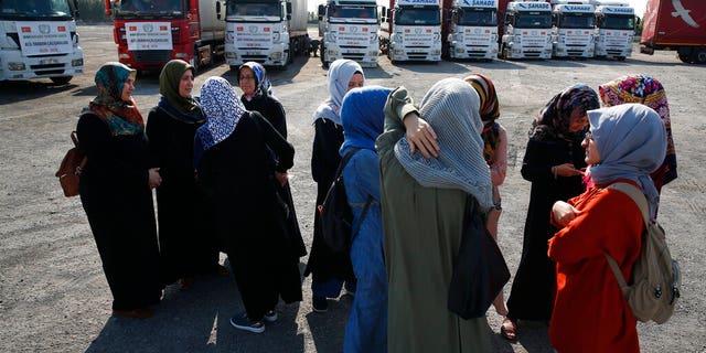 FILE - In this Sept. 10, 2018 file photo, members of a Turkish pro-government aid group, wait for the departure of trucks carrying humanitarian aid destined for Idlib, Syria, in Istanbul. (AP Photo/Lefteris Pitarakis, File)