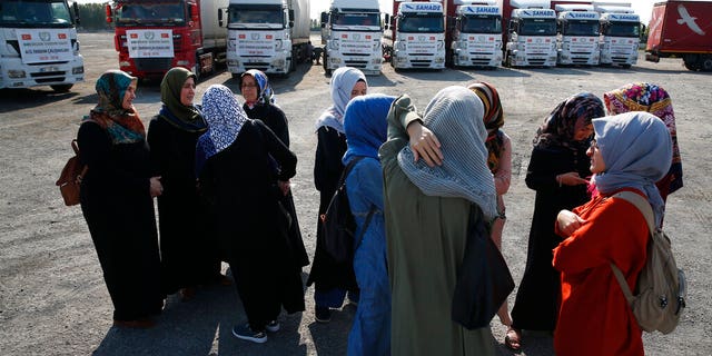 FILE - In this Sept. 10, 2018 file photo, members of a Turkish pro-government aid group, wait for the departure of trucks carrying humanitarian aid destined for Idlib, Syria, in Istanbul. (AP Photo/Lefteris Pitarakis, File)