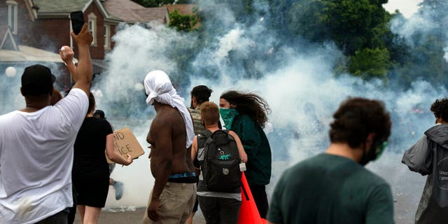 Protesters against police brutality clash with police during a march near where 20-year-old Hakeem Littleton was killed in a shootout with Detroit police earlier in the day, Friday July 10, 2020, in Detroit. (Nicole Hester/Ann Arbor News via AP)