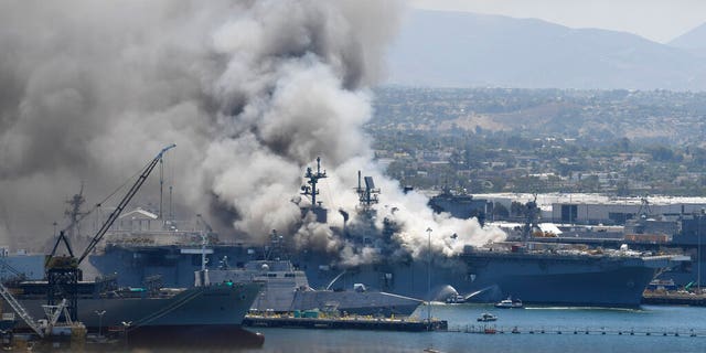 Smoke rises from the USS Bonhomme Richard at Naval Base San Diego Sunday, July 12, 2020, in San Diego after an explosion and fire Sunday on board the ship at Naval Base San Diego. 