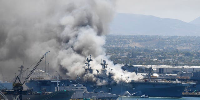 Smoke rises from the USS Bonhomme Richard at Naval Base San Diego Sunday, July 12, 2020, in San Diego after an explosion and fire Sunday on board the ship at Naval Base San Diego.