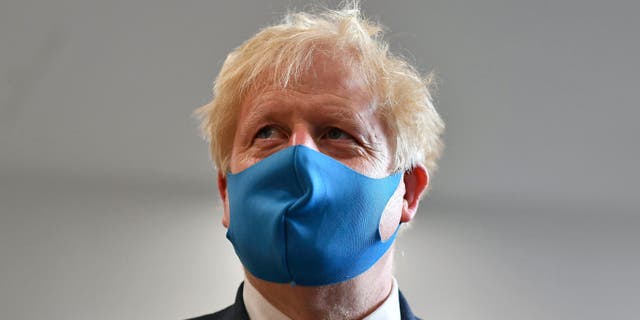 Britain's Prime Minister Boris Johnson, wearing a face mask, visits the headquarters of the London Ambulance Service NHS Trust in London, Monday July 13, 2020. (Ben Stansall/Pool via AP)