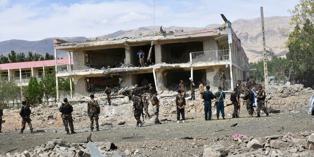 Afghan security personnel inspect the site of a car bomb blast on an intelligence compound in Aybak, the capital of the Samangan province in northern Afghanistan, July 13. Taliban insurgents launched a complex attack on the compound that began with a suicide bombing, officials said. (AP Photo)