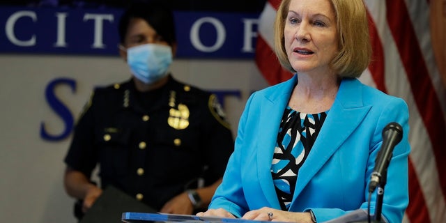 Seattle Mayor Jenny Durkan, right, speaks, Monday during a news conference at City Hall in Seattle. Durkan and Police Chief Carmen Best, looking on at left, were critical of a plan backed by several city council members that seeks to cut the police department's budget by 50 percent. (AP Photo/Ted S. Warren)