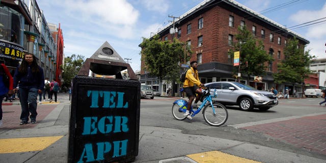 FILE - In this July 18, 2019, file photo, traffic and pedestrians cross Telegraph Avenue in Berkeley, Calif. The politically liberal city of Berkeley in Northern California is considering a proposal to shift traffic enforcement from armed police to unarmed city workers. (AP Photo/Jeff Chiu, File)