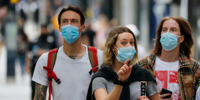Shoppers wearing protective face masks walk along Oxford Street in London, Tuesday, July 14, 2020. Britain’s government is demanding people wear face coverings in shops as it has sought to clarify its message after weeks of prevarication amid the COVID-19 pandemic. (AP Photo/Frank Augstein)