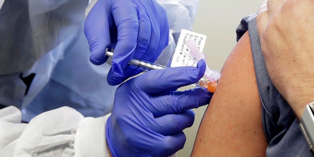 A subject receives a shot in the first-stage safety study clinical trial of a potential vaccine by Moderna for COVID-19, the disease caused by the new coronavirus on March 16, 2020. (AP Photo/Ted S. Warren, File)