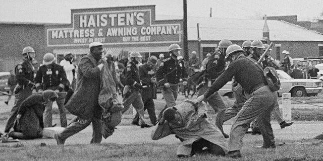 In this file photo dated March 7, 1965, a soldier wields a billy club in John Lewis, in the right foreground, chairman of the Student Nonviolent Coordinating Committee, to break off a civil rights march in Selma, Ala.  Lewis suffered a fractured skull.  (AP photo / file)