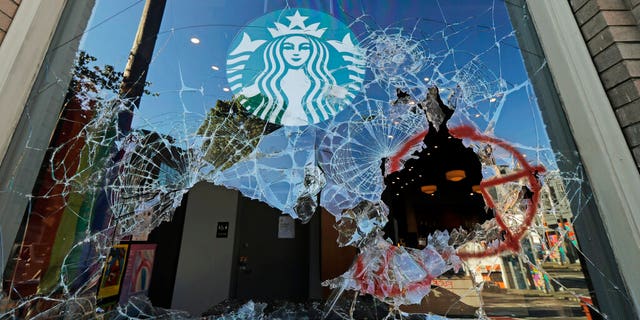 Broken windows are shown at a Starbucks store, Sunday, July 19, 2020 in Seattle's Capitol Hill neighborhood. Protesters broke windows at the store earlier in the afternoon. (AP Photo/Ted S. Warren)