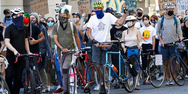 Bicyclists maintain a line to help protect marchers from traffic during a protest led by youth activists demanding racial, climate, economic, worker, and social justice Monday, July 20, 2020, in Seattle. The demonstration follows other protests over the death of George Floyd, a Black man who was in police custody in Minneapolis. 