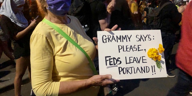 Mardy Widman, a 79-year-old grandmother of five, protests the presence of federal agents outside the Mark O. Hatfield Federal Courthouse in Portland, Ore., Monday, July 20, 2020. (AP Photo/Gillian Flaccus)