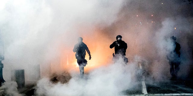 Federal officers use crowd control munitions to disperse Black Lives Matter protesters outside the Mark O. Hatfield United States Courthouse on Tuesday in Portland, Ore. On Thursday, a federal judge denied an order to prevent federal agents from arresting people during nightly protests in Portland. (AP Photo/Noah Berger)