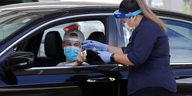 A health care worker takes information from a person at a COVID-19 testing center on July 21, 2020, in Pleasanton, Calif. (AP Photo/Ben Margot)