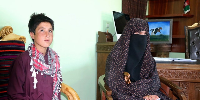 Qamar Gul, 16, right, and her brother Habibullah, 12, pose for a photograph in the governor's office in Feroz Koh, the provincial capital of Ghor province, in western Afghanistan, Tuesday, July 21, 2020. (AP Photo)