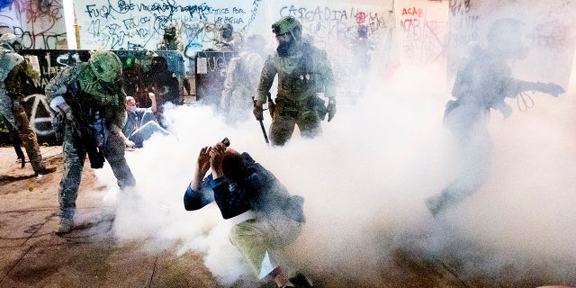 Federal officers use chemical irritants and crowd control munitions to disperse Black Lives Matter protesters outside the Mark O. Hatfield Federal Courthouse on Wednesday, July 22, 2020, in Portland, Ore. (AP Photo/Noah Berger)