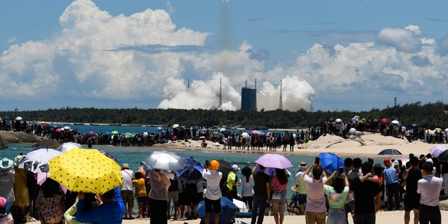 Spectators watch as a Long March-5 rocket carrying the Tianwen-1 Mars probe lifts off from the Wenchang Space Launch Center in southern China's Hainan Province, Thursday, July 23, 2020. China launched its most ambitious Mars mission yet on Thursday in a bold attempt to join the United States in successfully landing a spacecraft on the red planet. (Yang Guanyu/Xinhua via AP)