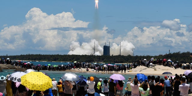 Spectators watch as a Long March-5 rocket carrying the Tianwen-1 Mars probe lifts off from the Wenchang Space Launch Center in southern China's Hainan Province, Thursday, July 23, 2020. China launched its most ambitious Mars mission yet on Thursday in a bold attempt to join the United States in successfully landing a spacecraft on the red planet. (Yang Guanyu/Xinhua via AP)