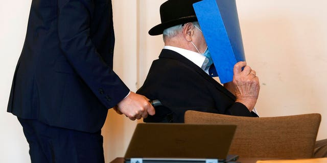 The 93-year-old German Bruno D., accused of being an SS guard involved in killings of thousands of prisoners, many of them Jewish, between August 1944 and April 1945, in the Stutthof Nazi concentration camp near Gdansk, Poland, arrives for expecting his verdict in his trial, in a Hamburg court room, Germany, July 23, 2020. (Fabian Bimmer/Pool via AP)