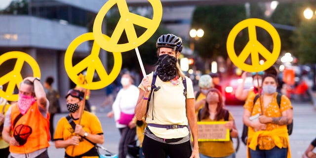 Mary Hubert, part of a "wall of moms," holds a peace sign during a Black Lives Matter rally on Wednesday, July 22, 2020, in Portland, Ore.