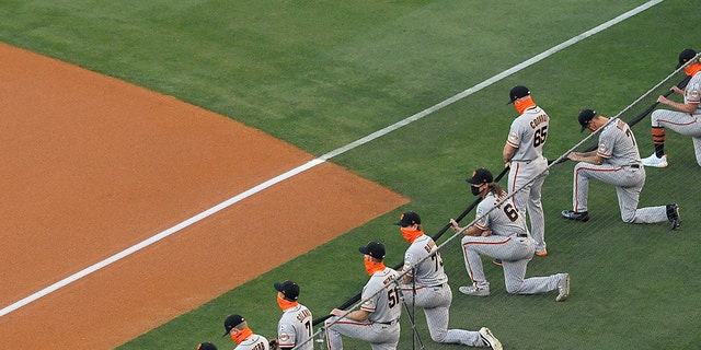 Most members of the San Francisco Giants kneel during a moment of silence prior to an opening day baseball game against the Los Angeles Dodgers, July 23, in Los Angeles. (AP Photo/Mark J. Terrill)