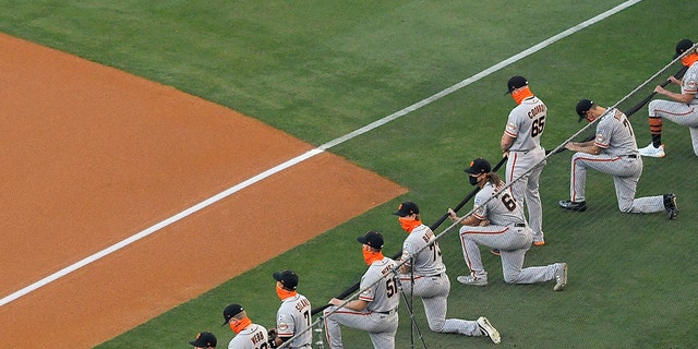 Most members of the San Francisco Giants kneel during a moment of silence prior to an opening day baseball game against the Los Angeles Dodgers, July 23, in Los Angeles. (AP Photo/Mark J. Terrill)