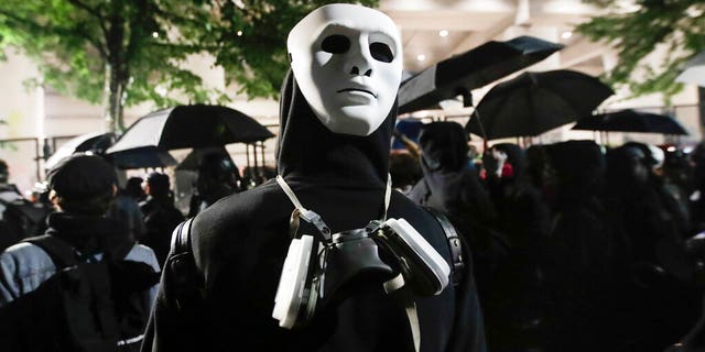 A demonstrator wears a mask on the back of his head during a Black Lives Matter protest at the Mark O. Hatfield United States Courthouse Thursday, July 23, 2020, in Portland, Ore.