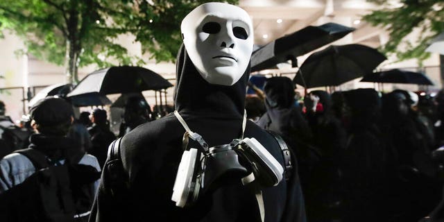 A demonstrator wears a mask on the back of his head during a Black Lives Matter protest at the Mark O. Hatfield United States Courthouse Thursday, July 23, 2020, in Portland, Ore. 