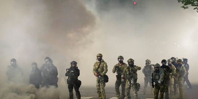 Federal officers advance on demonstrators during a Black Lives Matter protest at the Mark O. Hatfield United States Courthouse Friday, July 24, 2020, in Portland, Ore.