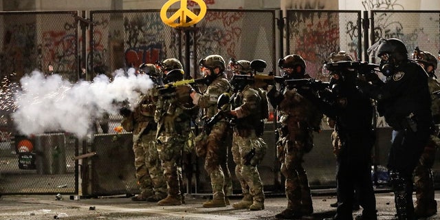 Federal agents use crowd control munitions to disperse Black Lives Matter demonstrators during a protest at the Mark O. Hatfield United States Courthouse Friday in Portland, Ore. (AP Photo/Marcio Jose Sanchez)