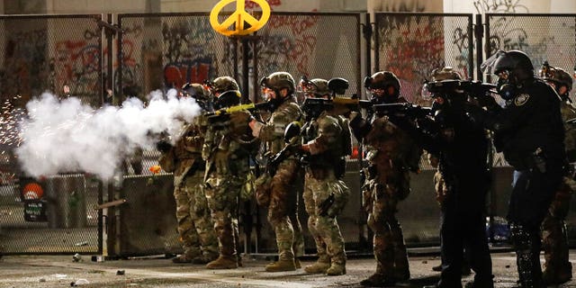 Federal agents use crowd control munitions to disperse Black Lives Matter demonstrators during a protest at the Mark O. Hatfield United States Courthouse Friday, July 24, 2020, in Portland, Ore. 