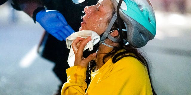 A medic treats Black Lives Matter protester Lacey Wambalaba after exposure to chemical irritants deployed by federal officers at the Mark O. Hatfield United States Courthouse on Friday, July 24, 2020, in Portland, Ore. Since federal officers arrived in downtown Portland in early July, violent protests have largely been limited to a two block radius from the courthouse.