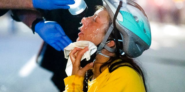 A medic treats Black Lives Matter protester Lacey Wambalaba after exposure to chemical irritants deployed by federal officers at the Mark O. Hatfield United States Courthouse on Friday, July 24, 2020, in Portland, Ore. Since federal officers arrived in downtown Portland in early July, violent protests have largely been limited to a two block radius from the courthouse. (AP Photo/Noah Berger)