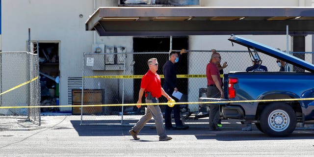 Fire investigators stand outside the Arizona Democratic Party headquarters Friday, July 24, 2020, in Phoenix. Fire investigators were looking into the cause of an early morning blaze that destroyed part of the Arizona and Maricopa County Democratic Party headquarters Friday. (AP Photo/Matt York)