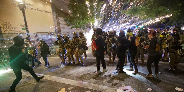 Federal officers advance on demonstrators during a Black Lives Matter protest at the Mark O. Hatfield United States Courthouse Saturday, July 25, 2020, in Portland, Ore. (Associated Press)