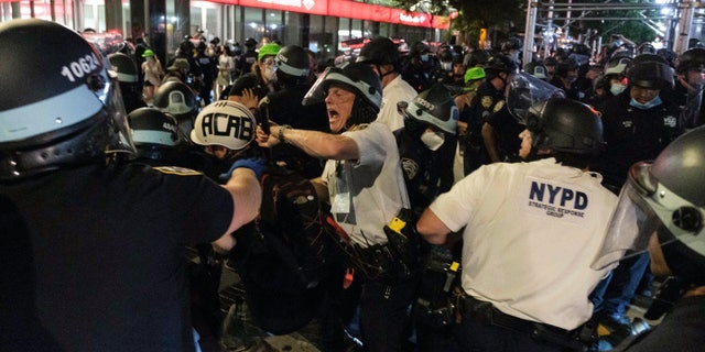 New York Police Department officers clash with demonstrators during a "Solidarity with Portland," protest, Saturday, July 25, 2020, in New York. (AP Photo/Yuki Iwamura)