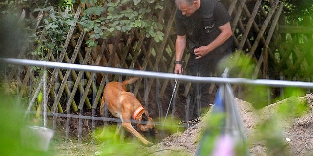 Germany police officers search with dogs an allotment garden plot in Seelze, near Hannover, Germany, Wednesday, July 29, 2020. (AP Photo/Martin Meissner)