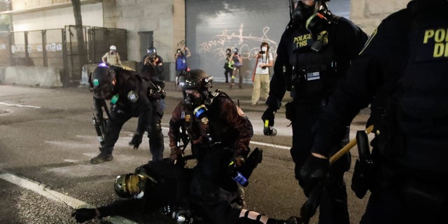 Federal agents arrest a demonstrator during a Black Lives Matter protest at the Mark O. Hatfield United States Courthouse Wednesday, July 29, 2020, in Portland, Ore. (AP Photo/Marcio Jose Sanchez)