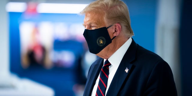 President Donald Trump wears a face mask as he tours the American Red Cross national headquarters in Washington, Thursday, July 30, 2020. (Doug Mills/The New York Times via AP, Pool)