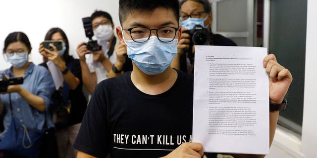 Hong Kong pro-democracy activist Joshua Wong shows his disqualification notice during a press conference in Hong Kong, July 31. (AP Photo/Kin Cheung)