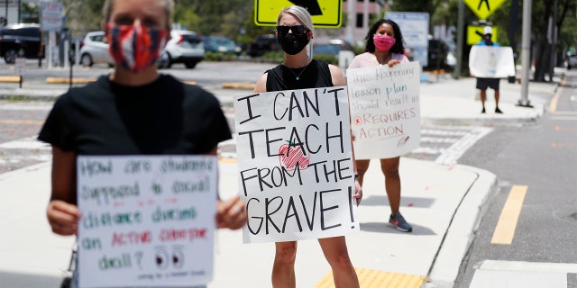 TAMPA, FL - JULY 16: Middle school teacher Brittany Myers, (C) stands in protest in front of the Hillsborough County Schools District Office on July 16, 2020 in Tampa, Florida. Teachers and administrators from Hillsborough County Schools rallied against the reopening of schools due to health and safety concerns amid the COVID-19 pandemic. (Photo by Octavio Jones/Getty Images)