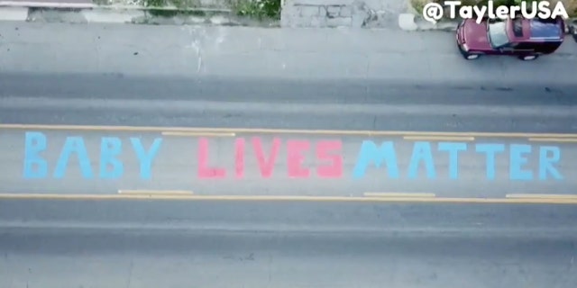Pro-life activist Tayler Hansen painted "Baby Lives Matter" in front of a Planned Parenthood clinic in Salt Lake City early Saturday morning before it was removed 10 hours later.
